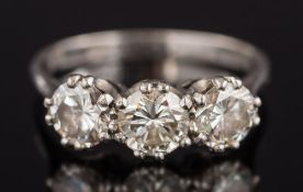 An 18ct white gold and diamond three stone ring: with circular,
