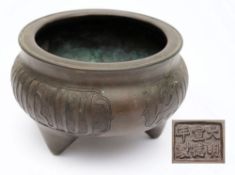A Chinese bronze tripod censer: of circular form, the sides with three panels of script,