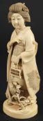 A Japanese carved ivory okimono of a Bijin: wearing traditional costume and holding a cage