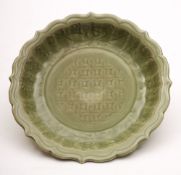 A Chinese Longquan celadon dish: with ribbed foliate rim, carved with scrolling lotus,