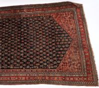 A Kashgai rug:, the indigo hexagonal field with an all over design of serated boteh medallions,