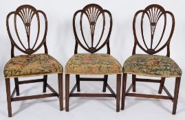 A set of six George III mahogany dining chairs in the Hepplewhite taste:,