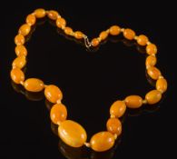 A graduated amber bead single string necklace: with 29 oval beads,