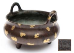 A Chinese gold splash bronze tripod censer: of compressed circular form with loop handles and peg