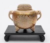 A Japanese Satsuma tripod koro and cover: of ovoid form with elephant head handles and reticulated