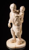 A Japanese carved ivory figure of a man with child on his back: Meilji period (1864-1912),