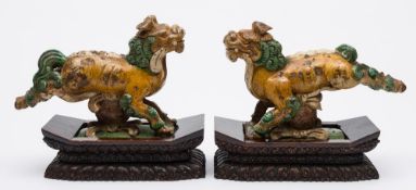 A pair of Chinese sancai glazed pottery roof tiles: in the form of Buddhistic lion dogs leaping
