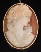 An oval shell cameo portrait brooch: depicting a classical woman, her hair adorned with curls,