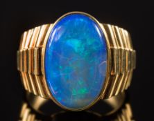 A gentleman's oval opal single stone ring: the opal approximately 18mm long x 12mm wide,
