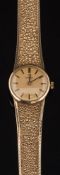A lady's 9ct gold Omega wristwatch: the circular gold colour dial with baton markers in a 9ct gold