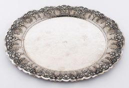An Eastern beaten white metal dish: of oval design with embossed flowerhead and foliate border, 39.