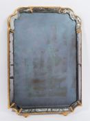 An 18th Century cartouche-shaped marginal wall mirror:, in a later gilt moulded frame,