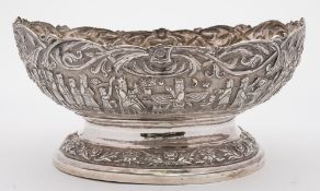 A Persian silver metal bowl: of oval form with embossed decoration of an enthroned king and