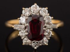 An 18ct gold, ruby and diamond oval cluster ring: with central oblong ruby 8.