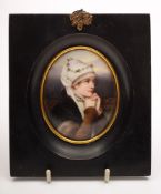 A small Continental porcelain portrait plaque: of oval form painted with a young girl in head scarf