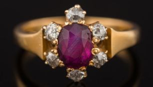 A late 19th century gold, ruby and diamond oval cluster ring: the oval ruby 5.5mm long x 4.