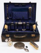 A George V period blue leather vanity case containing silver topped bottles, maker Finnigans Ltd,