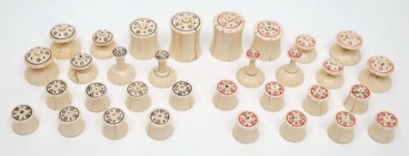 A 19th century Indian Muslim pattern ivory chess set: one side stained with red concentric rings,