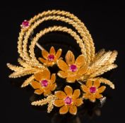 A ruby mounted floral spray brooch: set with six circular rubies, stamped '18k', 13gms gross weight.