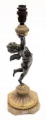 A 19th century bronze and gilt metal lamp: in the form of a cherub supporting an oil lamp,