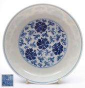 A Chinese blue and white peony saucer dish: painted with a medallion of scrolling peony flowers and