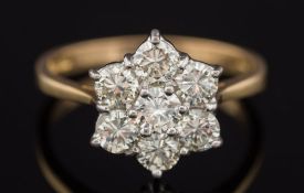 An 18ct gold and seven stone diamond, circular cluster ring: with round,