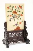 A Chinese hardstone table screen and wood stand: the rectangular panel applied with a knarled peony