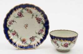A Worcester fluted tea bowl and saucer: painted with floral swags below a royal blue border,
