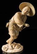 A Japanese sectional ivory okimono: Meiji period (1864-12) of a peasant wearing traditional clothes