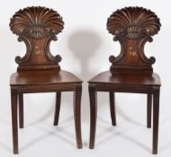 A pair of Regency carved mahogany hall chairs:,