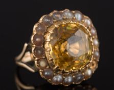A yellow sapphire and seed-pearl cushion-shaped cluster ring: with central cushion-shaped sapphire