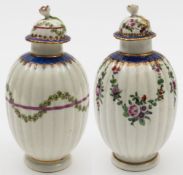 Two Worcester tea canisters and covers: both of reeded ovoid form with flower finials and gilded