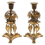 A pair of 19th century French ormolu candlesticks: with foliate decorated urn nozzles,