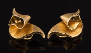 A pair of ribbon design ear clips: stamped '18K', 8.8gms gross weight.