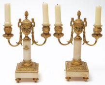 A pair of 19th century French ormolu and alabaster twin branch candelabra: with garland decorated
