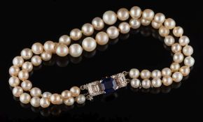 A graduated pearl/cultured pearl two-string bracelet: with sapphire and diamond mounted clasp:,