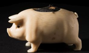 An early 20th century carved ivory pin cushion in the form of a pig: with inset glass eyes and