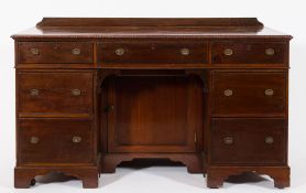 An Edwardian carved mahogany kneehole pedestal desk or dressing table:,