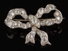 A diamond mounted 'ribbon bow' brooch: set with round old-cut diamonds estimated to weigh a total