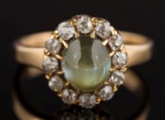 A chrysoberyl cat's eye and diamond oval cluster ring: the oval chrysoberyl 7.4mm long x 6.