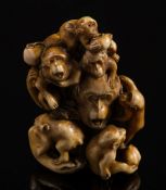 A Japanese carved ivory okimono of a group of monkeys: some holding nuts and fruit, signed Masatami,