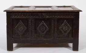 An 18th century oak rectangular coffer: with a hinged moulded panel top,