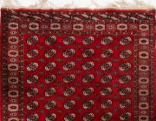 A Turkoman carpet:, the red field with an all over design of quartered and cruciform medallions,