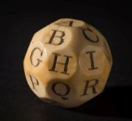 A 19th century ivory teetotum: with twenty six facets each carved and stained with a letter of the