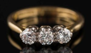 An 18ct gold and diamond three-stone ring: with circular,