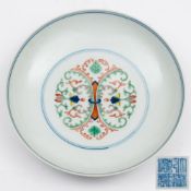 A Chinese doucai saucer dish: painted with a ring-tied foliate medallion within double circles,