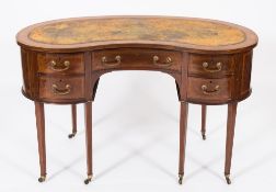 An Edwardian mahogany and inlaid kneehole desk:, of kidney-shaped outline, crossbanded in satinwood,