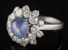 A star sapphire and diamond circular cluster ring: with central round star sapphire, 7.
