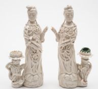 A pair of Chinese blanc de Chine figures of Guanyin: each goddess wearing jewelled robes and