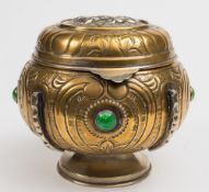 A Continental brass and silvered tobacco jar: the domed hinged lid inset with an oval panel of a